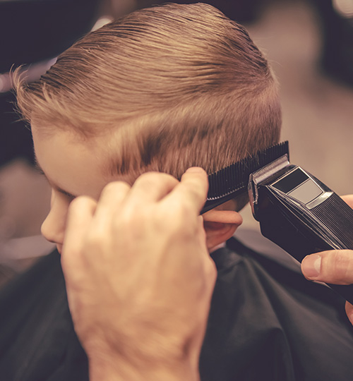 Le Coiffeur Coupe Des Cheveux D'un Garçon D'enfant Dans Le Salon